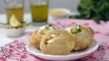 Hindistan 'dan taze nane yapraklarıyla lezzetli Golgappa' ları süsleyen Hint şef. Yakın çekim Pudina suyu, Aloo Bhujia, dilimlenmiş yeşil biber, soğan ve limon - Gol Gappa /