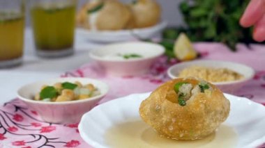 Hint kadınlarının el tatma / ev yapımı kıtır kıtır Golgappa - lezzetli atıştırmalıklar - Hindistan sokak yemekleri. Lezzetli Panipuris, dilimlenmiş limon, yeşil biber ve bir demet nane yaprağı - Gol Gappa / Phuchka