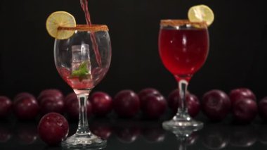 Bir dilim limonla süslenmiş taze erik suyu ve bir bardağa dökülen buz, Hint yaz meyvesi. Taze meyve suyuyla dolu bir bardak ve bir arada tutulan bir yığın kırmızı erik