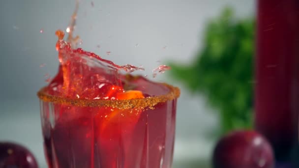一片红色的李子掉进了一杯用柠檬 印度夏季水果装饰的新鲜果汁里 一瓶果汁 几棵李子和新鲜的薄荷叶放在一起 — 图库视频影像