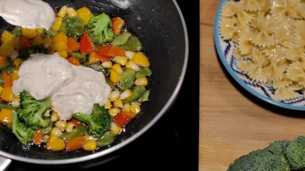 在用平底锅烹调的新鲜蔬菜中加入香草混合蛋黄酱 意大利法式面食排骨片正在一个电炉上准备 家常菜 — 图库视频影像