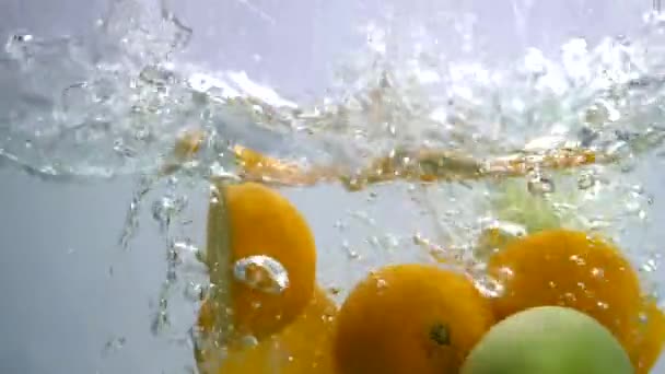 Modne Grønne Epler Saftige Appelsiner Som Faller Ferskt Kaldt Vann – stockvideo