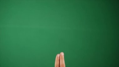 Elleri yeşil ekrana dokunan bir gencin parmakları. El hareketleriyle. Ekrana tıklayan bir insan elinin yakın çekim görüntüsü - yeşil kroma kurulumu