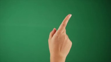 İşaret parmağını yeşil arka planda döndüren biri el hareketleriyle. Bir insanın sağ elinin kroma anahtarıyla parmaklarını değiş tokuş ederken yakın plan görüntüsü.