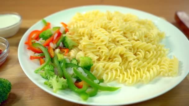 Uncooked Italian Rotini Pasta Sliced Green Capsicum Red Bell Peppers — Stock Video