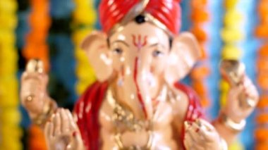 Turuncu ve sarı kadife çiçekleriyle süslenmiş Lord Ganesha heykeli. Hindu festivali. Ganesh Chaturthi festivali Hindistan 'da.