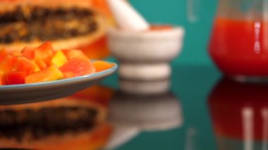  Bayan sabah kahvaltısı için masaya bir tabak sulu ve sağlıklı papaya koyuyor. Papaya, siyah tohumlar, papaya ezmesi ve tropikal meyvelerle ikiye bölünmüş. Sağlıklı beslenme, kilo kaybı gıdası.