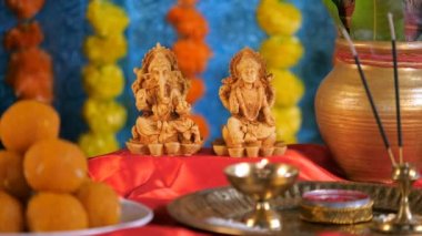 Ganesh Chaturthi 'de Lord Ganesha ve Devi Laxshmi' ye kadife çiçeği sunan bir kadın. Dini Pooja Thali - bir tabak tatlı ve bir Kalash. Hindu festivali, tapınakta dua, Diwali Pooja