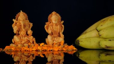 Hindu tanrısı Ganesha ve Tanrıça Laxmi 'nin önünde parlak bir şekilde Diya' yı yakmak. Ganesh Puja töreninde Prasad olarak sunulan besin değeri yüksek muz meyvesi cam bir masada duruyordu.
