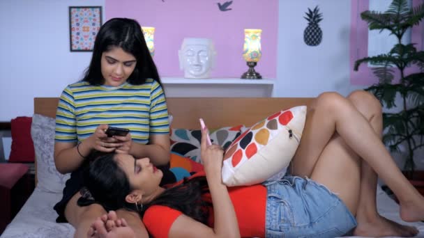 Jovens Irmãs Indianas Verificando Seus Smartphones Enquanto Relaxam Cama Casa — Vídeo de Stock