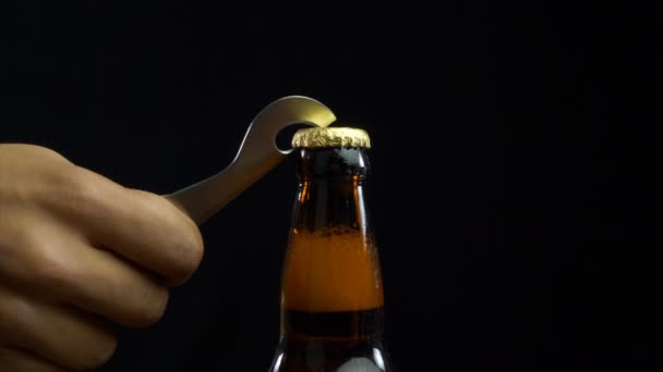 Menschliche Hand Öffnet Eine Braune Bierflasche Mit Goldenem Deckel Ein — Stockvideo
