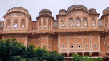 Pembe şehir Jaipur 'daki güzel şehir sarayının çekimleri. Turizm konsepti. Kırmızı ve pembe kumtaşından yapılmış ve doğayla çevrili harika şehir sarayının çekimi - Rajasthan, Hindistan