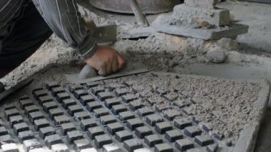 Vantilatör çerçevesine çimento ekleyen bir işçinin yakın plan çekimi.. 