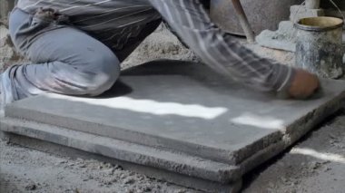 Hintli işçiler yüzen elle beton yüzeyi pürüzsüz hale getiriyor. İşçi ellerinin kapanışı beton vantilatöre son rötuşu bir güç şamandırası yardımıyla veriyor.