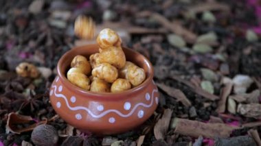 Nilüfer çekirdeği, Makhana ile dolu bir çömleğin içine düşüyor. Sağlıklı atıştırmalık. Hint baharatları Javitri, Jaiphal, yıldız anason, tarçın ve kakule bir masanın üzerine serpiştirilmiş - yemek malzemeleri, mide sağlığı, sindirim sıkıntısı