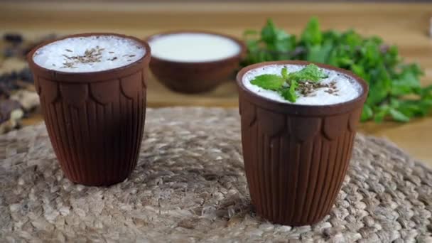 Two Glasses Chaas Seasoned Cumin Seeds Mint Leaves Rotating Turntable — Stock Video