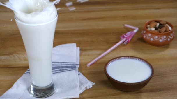 Sebuah Batu Besar Jatuh Dalam Gelas Transparan Dengan Buttermilk Menyegarkan — Stok Video