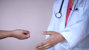 Kadın doktor, klinikteki genç bir hastanın nabzını kontrol ediyor. Sağlık çalışanı kalp atışlarını kontrol etmek için hastanın bileğini kontrol ediyor. Sağlıklı yaşam tarzı, kan basıncını kontrol altında tutmak.