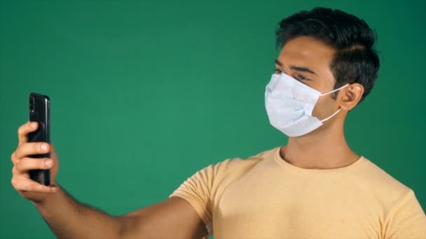 Ένας Νεαρός Άνδρας Που Μιλάει Βιντεοκλήση Φορώντας Ιατρική Μάσκα Covid — Αρχείο Βίντεο