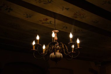 Tarih binasında tavan resimleri olan güzel bir seramik avize. Eski dekore edilmiş bir odada antik bir ışık..