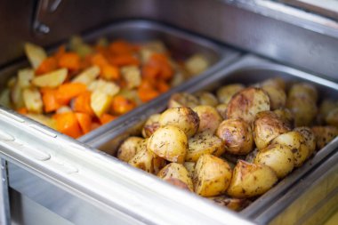 Fırında patates ve diğer sebzeler. Vejetaryen yemeği. Bir yaz partisinde sağlıklı yemek servisi büfesi..