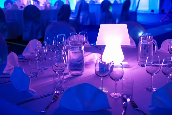 Table setting for elegant dinner with mushroom lamp and UV light. Large party setup.