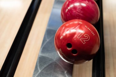 Brunswick bowling topları piste dizilmişti. Dönüş makinesinde topları olan bowling salonu şeridi.
