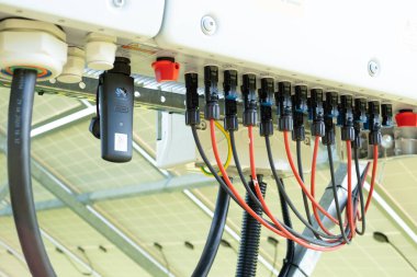 Huawei güneş paneli fotoelektrik jeneratör ve kablolar. Huawei jeneratörü güneş panelinin altında yeşil çimen tarlasında.