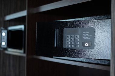 Küçük siyah kasa. Otel odasında dijital kodlu küçük bir kasa. Para ve değerli eşyalar için saklanma yeri