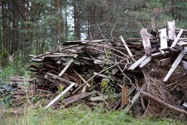 Old broken building materials in nature, demolition waste. Huge pile of construction waste stacked in the forest waiting to be burnt, recycled