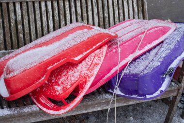 Karların altında farklı renkte kızaklar. Çocuklar için kış aktiviteleri.