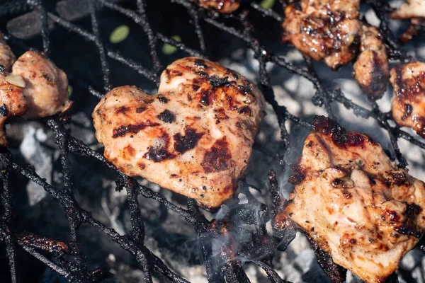 Meat lover. Love BBQ chicken. Fun cooking. Heart shaped piece of chicken meat cooking on hot grill.