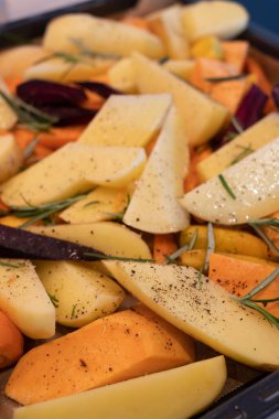 Taze kesilmiş ve baharatlı sebzeler fırın pişirmeye hazır. Fırın tepsisinde kızartılmış sebze hazırlıyorum..