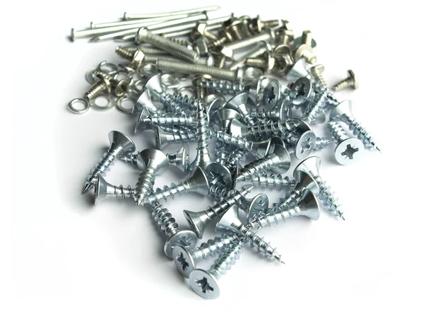 Screws, bolts, nails and different type of metal on white backgr Royalty Free Stock Photos