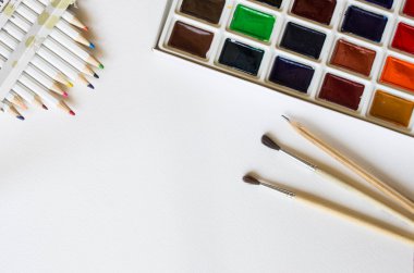 Profesyonel suluboya resim yapıyor, renkli kalemler ve üzerinde fırçalar bir