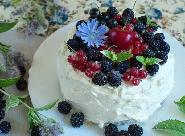 Handmade cake with sweet cream blackberries and red currants