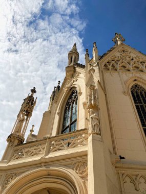Lednice Kalesi 'nin neo-gotik binasının alt manzarası. Mavi bulutlu gökyüzünün arka planında taretler var.