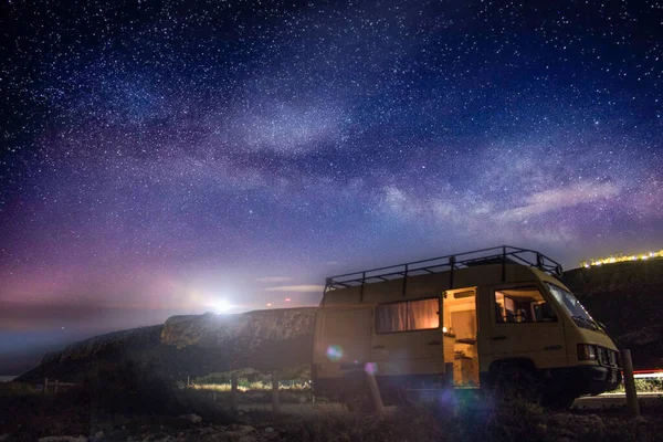 Güzel yıldızlı bir gece. Arka planda bir deniz feneri ve bir karavan var.