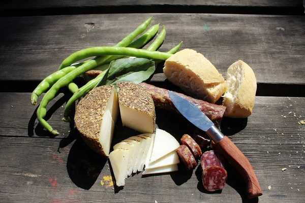 Yemek, geleneksel İspanyol yemeği İspanya, peynir, fasulye, ekmek ve salçun. Tahta bir masada ustura ile kesilmiş.