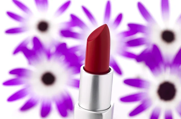 Lipstick and flowers on background — Stock Photo, Image