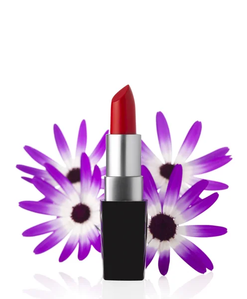 Lippenstift und Blumen auf Hintergrund — Stockfoto