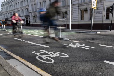 Cardiff, Wales - 3 Şubat 2021: Cardiff City Centre 'dan yeni geliştirilen Cardiff Konseylerinden biriyle iki bisikletçi geçiyor.
