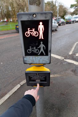 Cardiff, Galler - 3 Şubat 2021: Bir yaya geçidi üzerinde bir yaya düğmesine basıyor