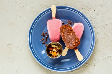 Çikolata ve çilekli dondurma tabakta.