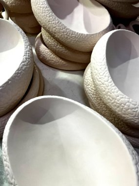 Eşsiz doku ve şekillere sahip el yapımı seramiklerin yakın görüntüsü, çömlekçilik atölyesinde parlatılmaya hazır..