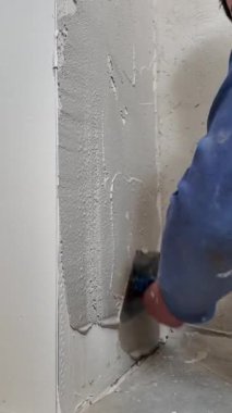 İşçi yenileme sırasında duvarın yüzeyine alçıyı sorunsuzca yaymak için mala kullanıyor. İşlem, düzgün duvar bitirme işlemi için gerekli adımları gösterir.