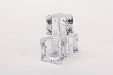 Şeffaf buz küpleri piramidi. Buz küpleri gri arka planda kapanıyor. Metin için boşluk