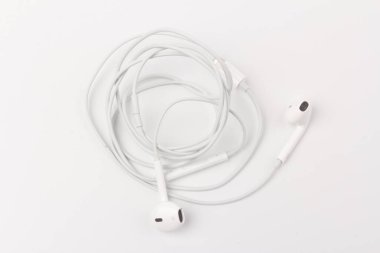 Portatif cihazlarda müzik ve ses dinlemek için beyaz kulaklıklar: beyaz arka planda bağlantı için müzik çalar, akıllı telefon, dizüstü bilgisayar ve jack. 