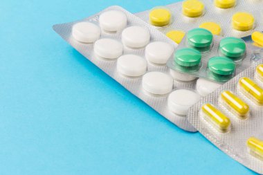 Mavi arka plandaki kapsüller. Uzayı kopyala Küresel sağlık hizmeti kavramı. İlaç endüstrisi..