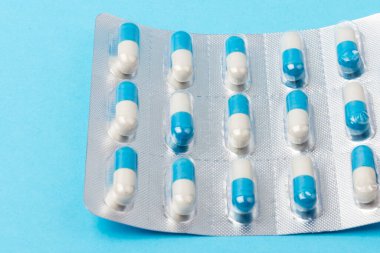 Mavi arka plandaki kapsüller. Uzayı kopyala Küresel sağlık hizmeti kavramı. İlaç endüstrisi..